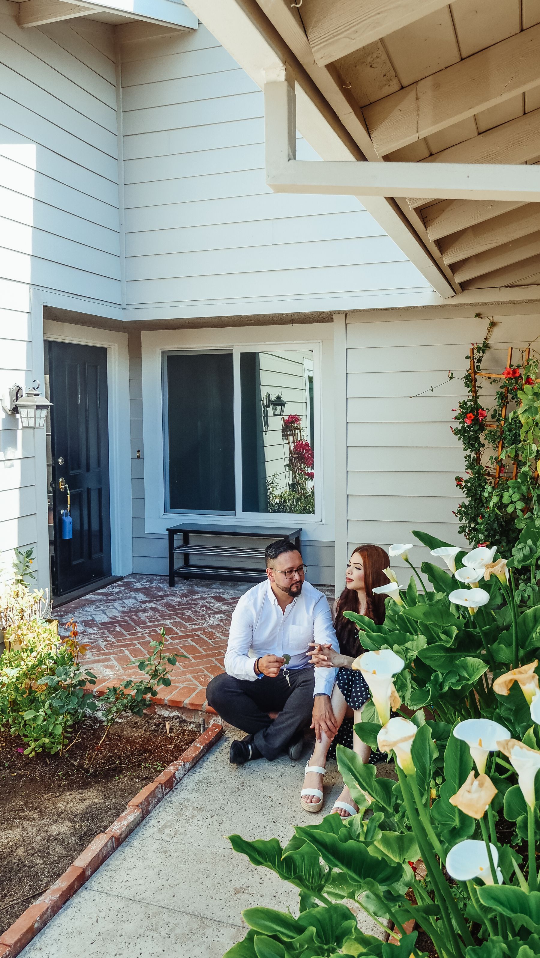 Homeowners sitting outside a well-kept residential home